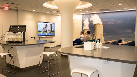 Geothermal power plant meeting room with two new employees reviewing training videos.